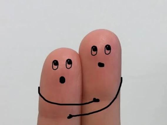 Two fingers with faces drawn on them